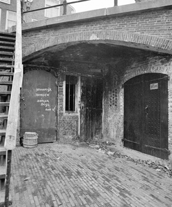 855386 Gezicht op de toegangsdeuren van de werfkelders onder Geertebrug over de Oudegracht te Utrecht, aan de westzijde ...